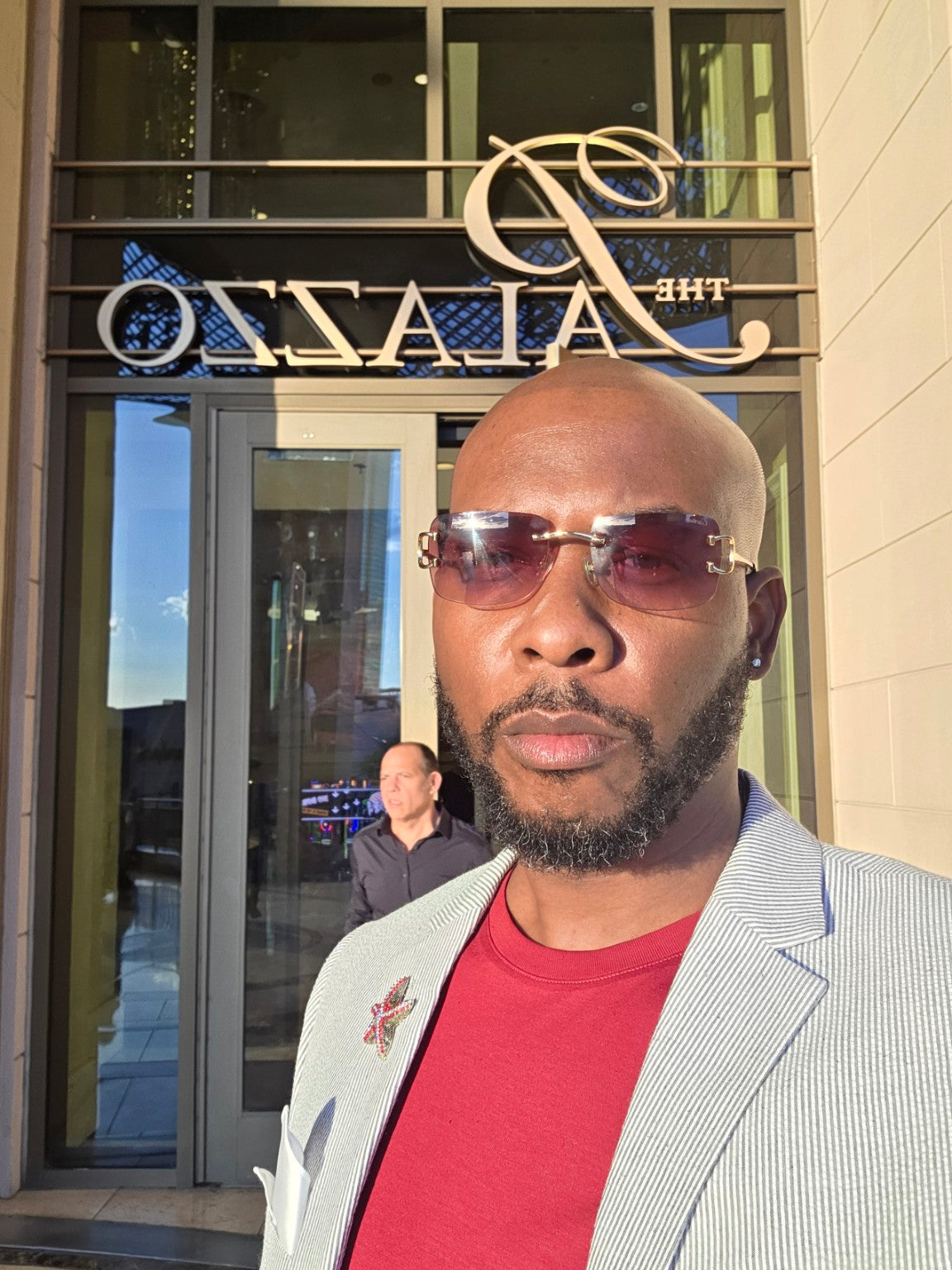 James Mack founder portrait in Miami wearing a tailored jacket and sunglasses